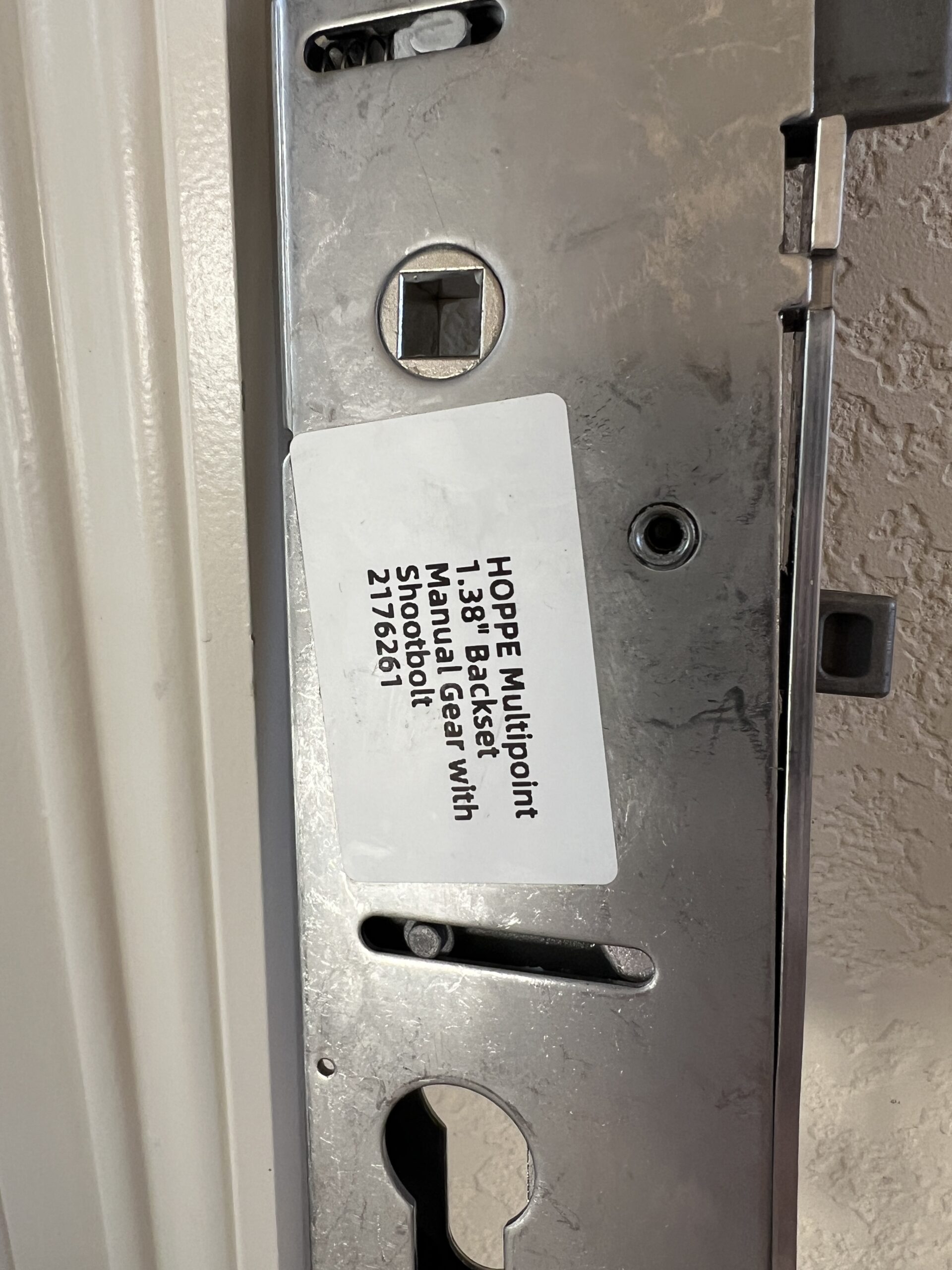 Close-up of a multipoint lock gearbox and handle connection during diagnosis